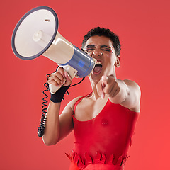 Image showing Anger, gay and portrait of a man with a megaphone isolated on a red background in a studio. Decision, freedom and person shouting and talking into a speaker while pointing with choice on a backdrop