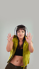 Image showing Music, dance and portrait of woman with headphones in studio, happy and excited isolated on grey background. Streaming service, song and gen z fashion, girl dancing with hands up to online radio dj.