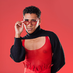 Image showing Fashion, portrait and gay man with glasses isolated on a red background in a studio. Lgbt, vision and stylish model person with fashionable eyewear, edgy clothes and funky style on a backdrop