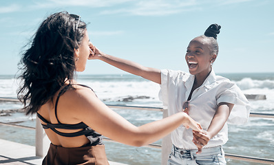 Image showing Friends, holding hands and women dance at beach, having fun and laughing together outdoors. Comic, freedom and girls laugh at funny comedy or joke, dancing and enjoying time at promenade seashore.