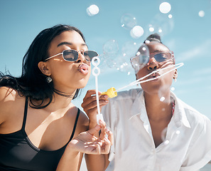 Image showing Woman, friends, and blowing bubbles by beach, ocean or sea on summer vacation, holiday travel or bonding activity. Women playing with soap or bubble wand or toy in fun game, freedom or social break