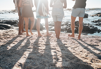 Image showing Friends, back or standing legs on beach, sand or ocean sea in social gathering, group vacation or summer holiday with guitar. Men, women or diversity people with musical instrument in travel bonding