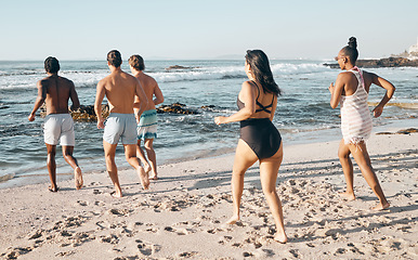 Image showing Bonding friends, swimwear or running to sea, ocean or beach water on summer holiday, fun vacation or relax travel break. Men, women or diversity people in swimsuit for diversity freedom or swimming