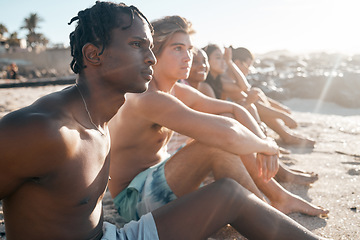 Image showing Black man, bonding and sitting on beach sand with friends in summer holiday, vacation break or community travel. Relax, diversity and people in swimsuit by sea for nature freedom or social gathering