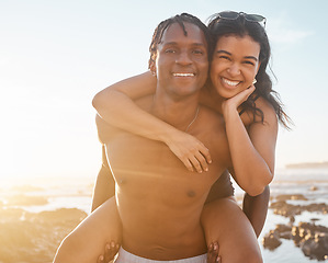 Image showing Fun couple, portrait or piggyback on sunset beach, ocean or sea in energy holiday, love vacation or summer travel. Smile, happy or man carrying black woman in bonding games, freedom trust or support