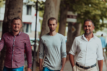 Image showing After a productive day at work, a group of diverse colleagues enjoy a leisurely stroll through a modern and natural urban setting