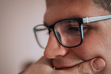 Image showing A programmer diligently testing smartphone applications while sitting in their office.