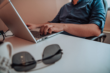 Image showing Close-up photo of a programmer typing on a laptop