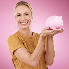 Image showing Woman, piggy bank and portrait for savings on pink background, studio and backdrop. Happy female holding financial tin for loan, profit or finance investment with cash, money and accounting budget