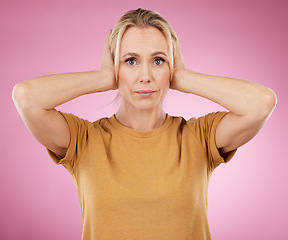 Image showing Stress, loud and portrait of a woman with a problem isolated on a pink background in a studio. Sound, frustrated and mature person covering and blocking ears from noise for silence on a backdrop