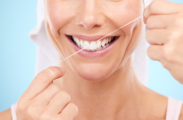 Image showing Floss, dental wellness and mouth of woman in studio for beauty, healthy face and happiness on blue background. Closeup model, tooth flossing and cleaning for facial smile, mint breath and happy teeth