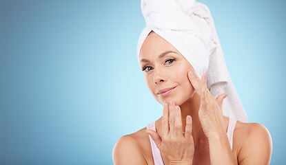 Image showing Towel, portrait and woman touch face in studio for beauty, dermatology or mockup blue background. Female model, skincare shower and facial aesthetic for healthy shine, glow transformation or cleaning