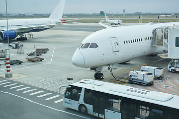 Image showing Airplane, bus and loading luggage outdoors for travel with heat pump for air conditioning for ac ventilation on journey. Global, transportation or commercial aeroplane on ground with cargo for flight