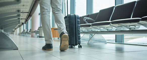 Image showing Airport, suitcase and person legs walking to flight for international opportunity or global journey in lobby. Luggage of entrepreneur or business man feet with vacation, travel agency or hospitality