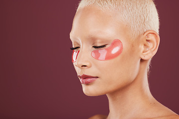 Image showing Eye patches, skincare and beauty of black woman doing face cleaning and wellness facial. Calm, skin glow and mockup of a young model in a studio for dermatology, collagen with maroon background