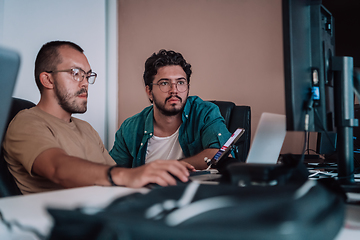 Image showing Programmers engrossed in deep collaboration, diligently working together to solve complex problems and develop innovative mobile applications with seamless functionality.