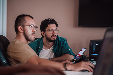 Image showing Programmers engrossed in deep collaboration, diligently working together to solve complex problems and develop innovative mobile applications with seamless functionality.