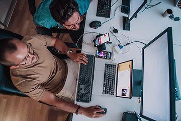 Image showing Programmers engrossed in deep collaboration, diligently working together to solve complex problems and develop innovative mobile applications with seamless functionality.