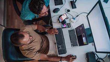 Image showing Programmers engrossed in deep collaboration, diligently working together to solve complex problems and develop innovative mobile applications with seamless functionality.