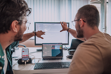 Image showing Programmers engrossed in deep collaboration, diligently working together to solve complex problems and develop innovative mobile applications with seamless functionality.