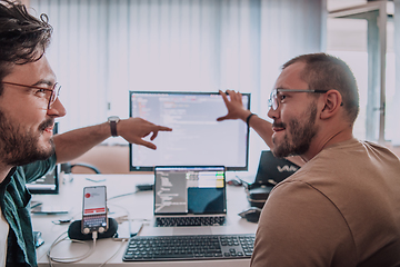 Image showing Programmers engrossed in deep collaboration, diligently working together to solve complex problems and develop innovative mobile applications with seamless functionality.