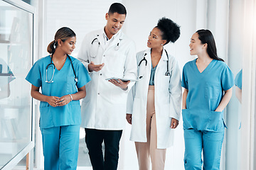 Image showing Doctor walkings, hospital tablet and healthcare talking and consulting with data. Teamwork, nurse collaboration and doctors in a wellness and health clinic with nurses discussion and diversity