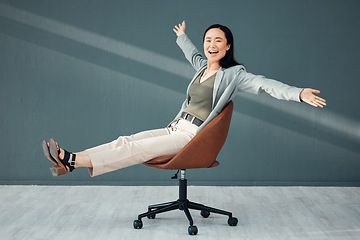 Image showing Portrait, chair and celebration of business woman for success, goals or achievements in office. Freedom, carefree and smile of happy Asian female riding on seat, laughing at joke or celebrate targets