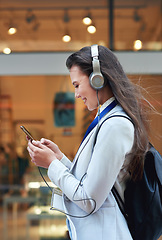 Image showing Business woman, phone and smile listening to music in the city for communication, social media or chat. Female walking and typing on smartphone with 5G connection, mobile app and earphones in a town