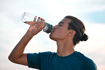 Image showing Fitness, drinking water and man with training, exercise and workout for balance, healthy lifestyle and thirsty. Male, athlete and runner with liquid, aqua and hydration after practice, sunset and sky