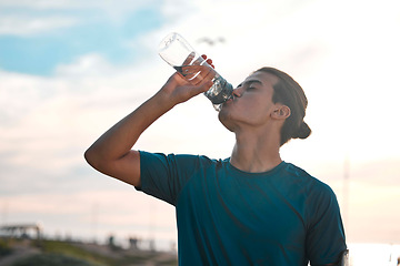 Image showing Fitness, exercise and man drinking water for wellness, healthy lifestyle and hydration after workout. Sports mockup, sunset and male athlete with minerals for running, endurance training and cardio