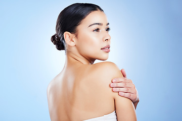 Image showing Skincare, woman and thinking in studio for beauty, dermatology and self love on blue background. Back of young female model, cosmetics and aesthetic for glow, shine or vision of facial transformation