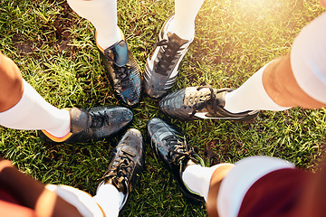 Image showing Shoes, huddle and team on grass field above for sports motivation, coordination or collaboration outdoors. Feet and legs of group in sport circle, fitness training or planning strategy ready for game