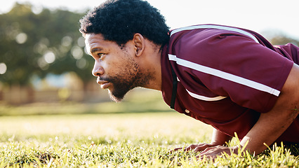 Image showing Sports, workout and man doing a push up on the field for training or practice before a game. Fitness, health and African male athlete doing a warm up exercise before a match by a grass stadium.