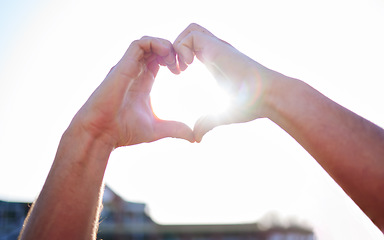 Image showing Love, heart and hands with sunshine, support and collaboration with light, mockup and outdoor. Closeup, zoom and sign with lens flare, community and peace with wellness, care and kindness outside