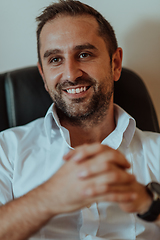 Image showing A successful businessman is sitting in his office after a hard day's work