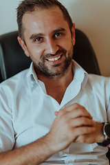 Image showing A successful businessman is sitting in his office after a hard day's work