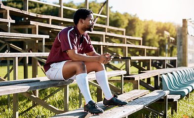 Image showing Rugby, sports or black man on pavilion thinking of training, exercise or workout game on grass field. Wellness, focus or African athlete with a vision, motivation or fitness goals sitting on a bench