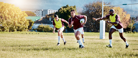 Image showing Rugby, athlete on field and sport game with men, team and player with ball, fitness and active outdoor. Exercise, sports training and running, teamwork with competition and action with energy
