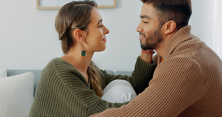 Image showing Love, support and happy with a couple in their home together, sharing an intimate moment with a kiss. Smile, talking and romance with a young man and woman kissing on a sofa in the living room