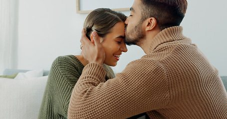 Image showing Love, support and happy with a couple in their home together, sharing an intimate moment with a kiss. Smile, talking and romance with a young man and woman kissing on a sofa in the living room