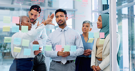 Image showing Meeting, collaboration and sticky notes with a business man training a team while planning strategy on glass in an office. Teamwork, diversity and workshop with a man and woman employee group at work