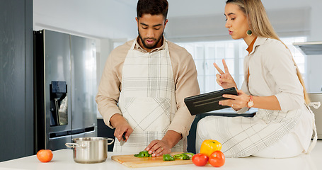 Image showing Couple, digital tablet and cooking with online recipe on the kitchen. Young man cutting vegetables and woman reading instructions on the internet, web or food website. while preparing healthy meal