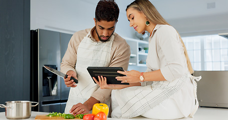 Image showing Couple, digital tablet and cooking with online recipe on the kitchen. Young man cutting vegetables and woman reading instructions on the internet, web or food website. while preparing healthy meal