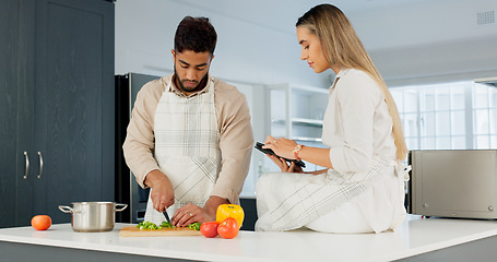 Image showing Couple, digital tablet and cooking with online recipe on the kitchen. Young man cutting vegetables and woman reading instructions on the internet, web or food website. while preparing healthy meal