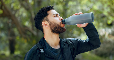 Image showing Man drinking water hiking in a forest, nature or woods outdoors in jungle adventure with freedom in Costa Rica. Healthy, fitness and thirsty hiker trekking or walking on a journey refreshing on break