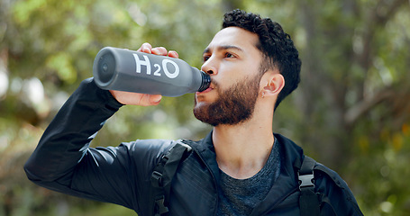 Image showing Man drinking water hiking in a forest, nature or woods outdoors in jungle adventure with freedom in Costa Rica. Healthy, fitness and thirsty hiker trekking or walking on a journey refreshing on break