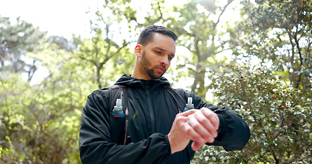 Image showing Forest, fitness and runner man smartwatch check for health stats or gps technology in Canada. Exercise, workout and athlete reading heart rate data on app or digital navigation on watch.