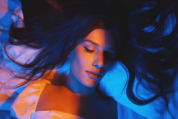Image showing Sleeping, vaporwave lights and woman with eyes closed in bedroom with creative disco lighting. Makeup, beauty and model resting and feeling relax and calm on a bed pillow with cyberpunk aesthetic