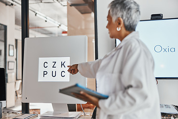 Image showing Letter eye exam, chart and senior woman doctor pointing to eyes test and clinic assessment sign. Consulting, optometrist and tablet of a healthcare employee in a office for wellness and health