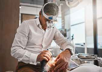 Image showing Healthcare, optometry and optometrist doing a cataract surgery on a senior patient in the clinic. Medical, eye care and male optician doing ophthalmology procedure for elderly woman at optical office